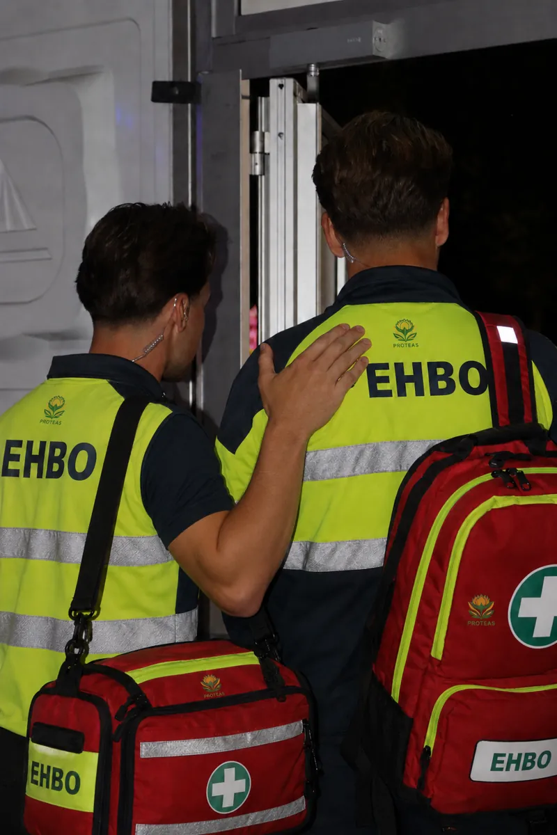 Twee EHBO'ers van Proteas met hesjes en EHBO-tassen.